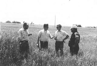 Old photo of staff and landowners meeting out in the field
